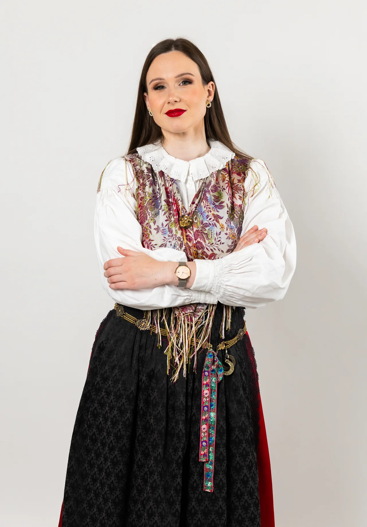Portret pevke v narodni noši s prekrižanimi rokami